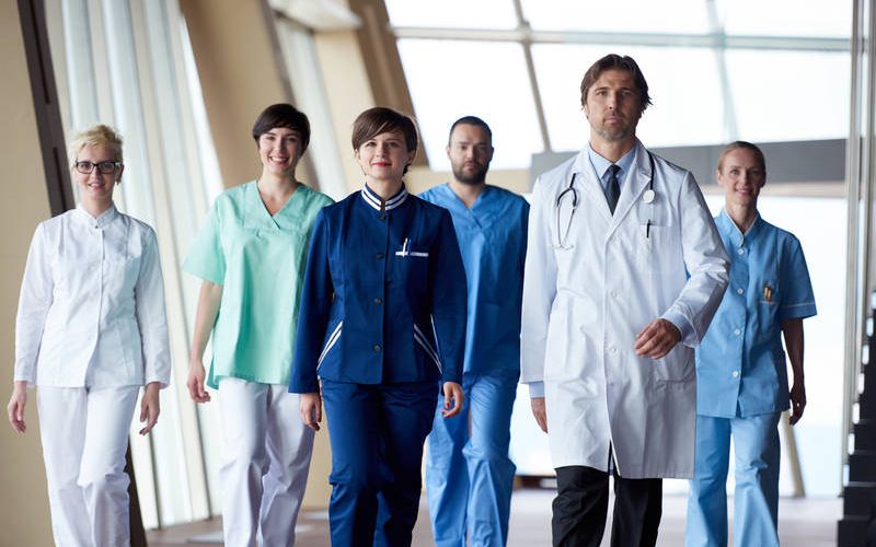 doctors team walking in modern hospital corridor indoors, poeople group