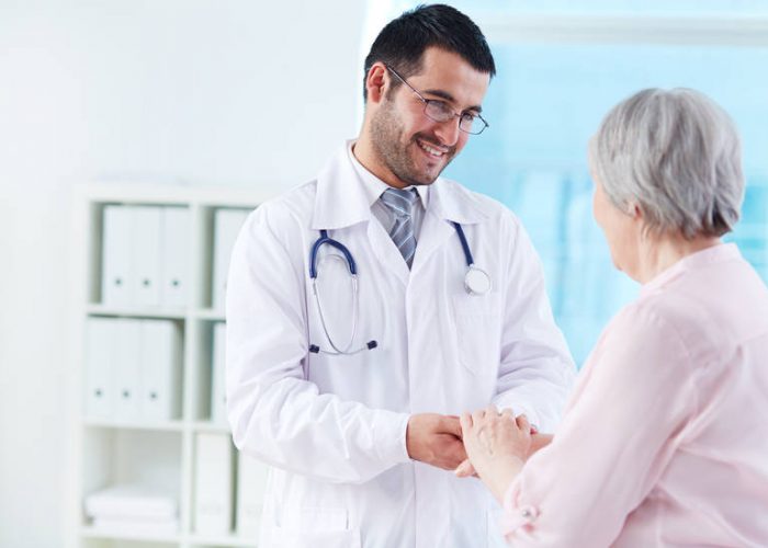 Confident doctor looking at his senior patient while speaking to her